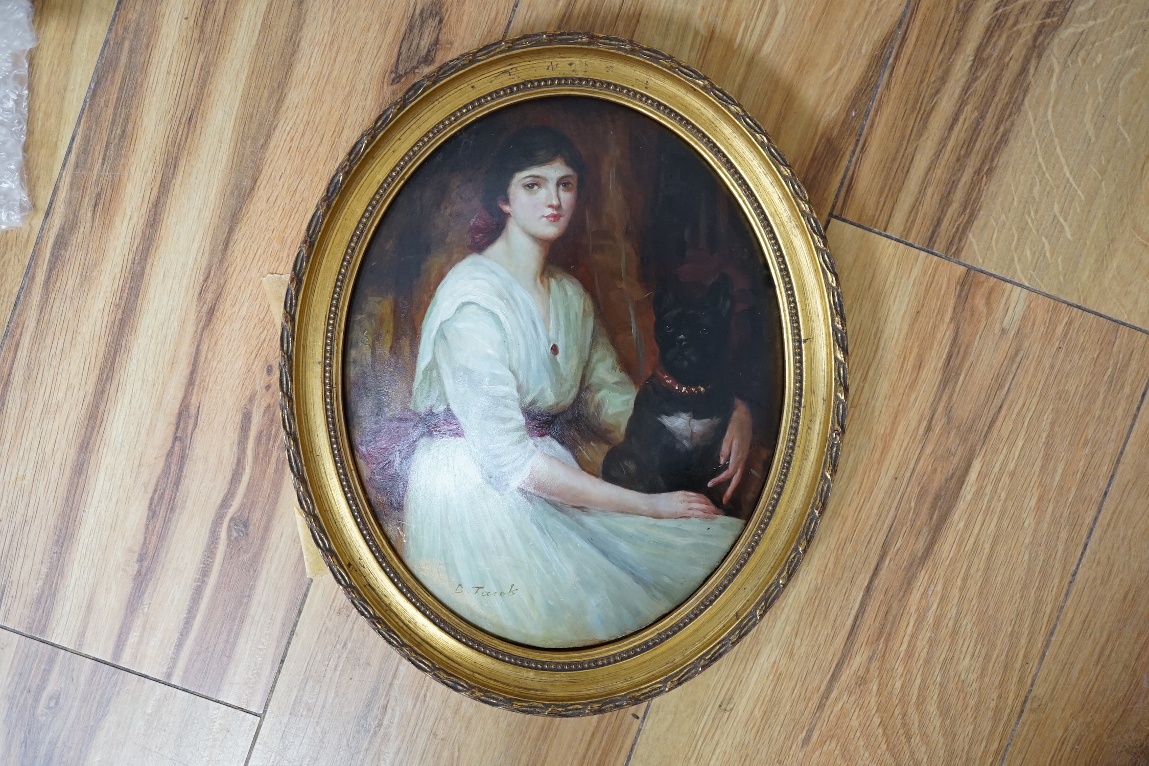 F. Jacob, oval oil on moulded composition, Study of a young lady with a dog, signed, 24 x 19cm, gilt frame. Condition - fair to good